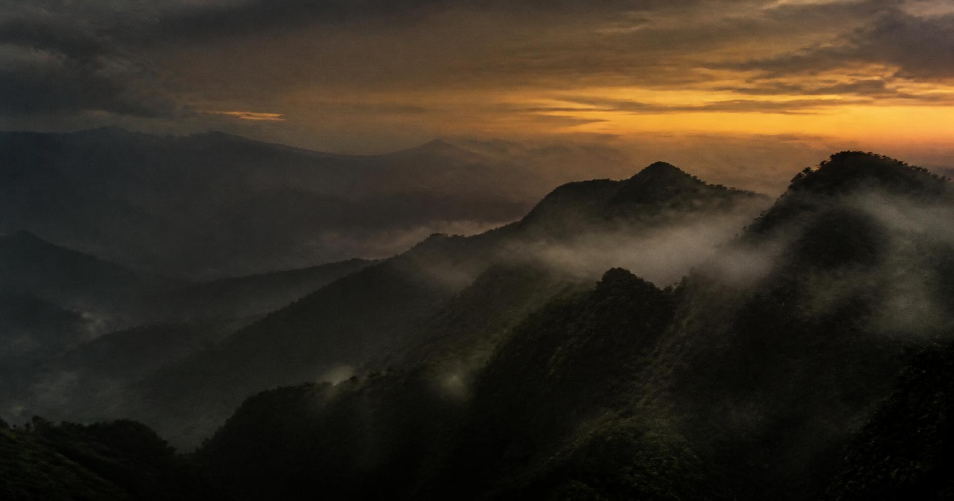 Fog drifting over the dark ridges of the Sierra Nevada de Santa Marta at dusk